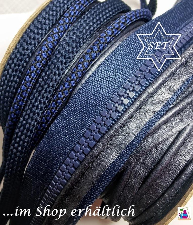 May include: A set of dark blue sewing supplies including a coiled zipper with plastic teeth, a braided cord, and a strip of textured material. A white star-shaped graphic with the text SET is visible, along with the text ...im Shop erh&auml;ltlich.