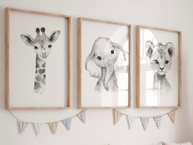 May include: Three framed black and white watercolor illustrations of animals. The illustrations are of a giraffe, an elephant, and a lion. The frames are light wood and the illustrations are on a white background.