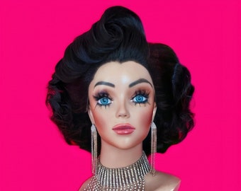 May include: A mannequin head with a black curly wig, blue eyeshadow, and a silver rhinestone necklace. The mannequin is wearing large silver rhinestone earrings.