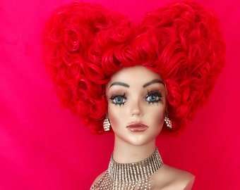 May include: A red heart-shaped wig with large curls. The wig is on a mannequin head with a silver rhinestone necklace.