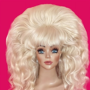 May include: A large, blonde wig with a bouffant style and loose curls. The wig is styled with a side part and bangs.