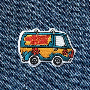 May include: A blue and yellow van with the words "Mystery Machine" on the side. The van has flowers and a white outline.