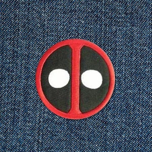 May include: Red and black circle with two white circles inside, resembling the Deadpool character's mask.