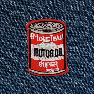 May include: Red and white embroidered iron-on patch of a can of motor oil. The can has the text "B4 ONE TEAM" and "MOTOR OIL" with the words "SUPER POWER" at the bottom.