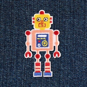 Può includere: Un robot di cartone animato con una testa gialla, un corpo rosa e gambe blu. Il robot ha braccia rosse e gambe a strisce rosse e bianche. Il robot ha un pannello blu sul petto con un pulsante rosso e un ingranaggio giallo.