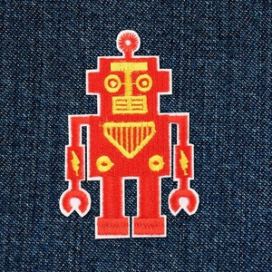 Könnte beinhalten: Roter Roboter-Patch mit gelben Details. Der Roboter hat einen runden Kopf mit zwei Augen, einem Mund und einer Antenne. Der Roboter hat zwei Arme mit Blitzen und zwei Hände mit abgerundeten Kanten. Der Roboter hat zwei Beine und zwei Füße.