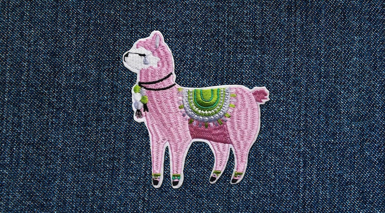 May include: Pink embroidered llama patch with green and white details. The llama is wearing a saddle with a green and white design.