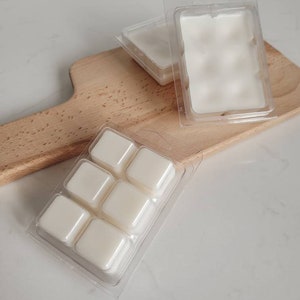 May include: A clear plastic tray with six individual wax melts. The wax melts are white and are in a square shape.