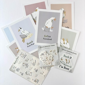 Könnte beinhalten: Eine Sammlung von Schreibwaren mit Enten-Illustrationen, darunter mehrere Grußkarten mit Texten wie Quack from Home und Entlich Feierabend, ein Bogen mit Quack Pack-Aufklebern und eine Packung mit Duck it I'm Done-Aufklebern.