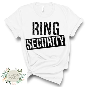 May include: White t-shirt with the words "RING SECURITY" printed in black, with the word "SECURITY" in a black rectangle. The shirt has rolled-up sleeves and a knot at the bottom. The Buena Vista Studio logo is in the lower left corner.