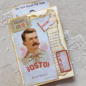 May include: A vintage baseball card featuring a portrait of Mike Kelly, a Boston player. The card has a red and white color scheme with the word "BOSTON" printed in red letters. The card is surrounded by other vintage ephemera, including a ticket for a "Summer Fun Park" ride and a small paper tag with the numbers 3, 4, 5, and 6 printed on it.