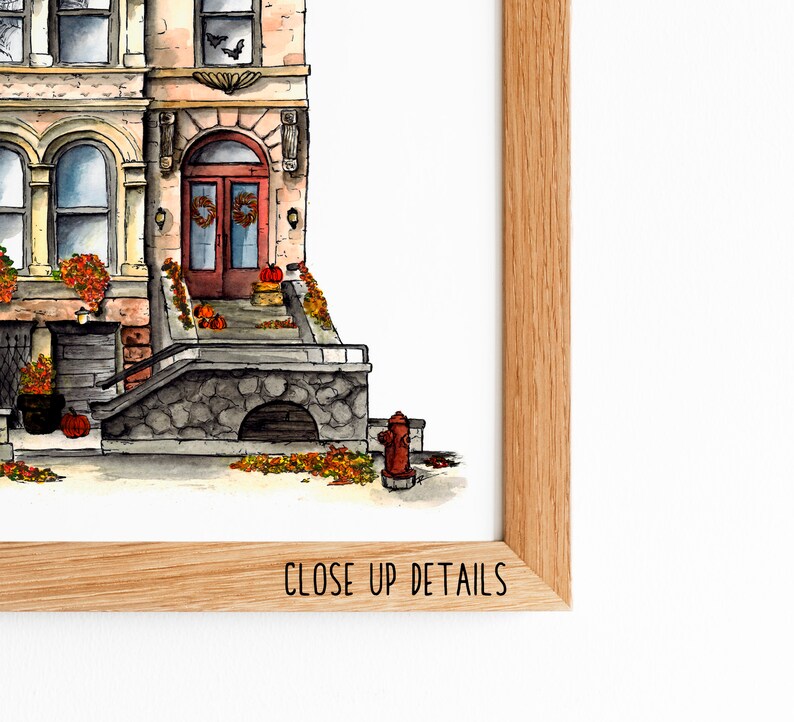 May include: Watercolor illustration of a brownstone building with a red door and a stone stoop. The building is decorated with fall foliage and pumpkins. The illustration is framed in a wooden frame with the text "CLOSE UP DETAILS" at the bottom.