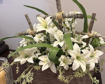 May include: A wooden box planter with white lilies and greenery. The planter is decorated with three wooden crosses tied with twine.
