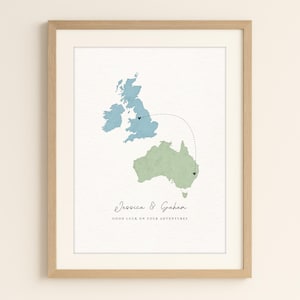 May include: Framed print with watercolour maps of the UK and Australia, linked by a dotted line. The UK is blue, Australia is green. Text reads "Jessica & Graham" and "Good Luck on Your Adventures."