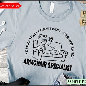 Peut inclure: T-shirt bleu clair avec un personnage de dessin animé se relaxant sur un canapé, tenant une boisson et une télécommande. Le t-shirt porte les mots "DEDICATION, COMMITMENT, PERSEVERANCE" et "ARMCHAIR SPECIALIST". Le t-shirt a aussi le texte "DIGITAL & SVG DESIGNS FOR YOU" et "SAMPLE PROJECT".