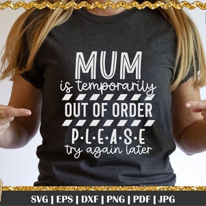 May include: Dark gray t-shirt with the text "MUM is temporarily OUT OF ORDER PLEASE try again later" in white. The shirt is being pointed at by a person. The image also includes the text "Digital & SVG Designs For You".
