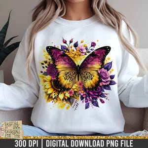 May include: White sweatshirt featuring a large, colorful butterfly design. The butterfly has yellow and purple wings with a leopard print pattern. Surrounding the butterfly are sunflowers and purple roses. The text "DIGITAL & SVG DESIGNS FOR YOU" is visible.