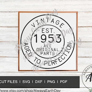 May include: A framed print with a white background and black text. The text reads "VINTAGE EST. 1953 ALL ORIGINAL PARTS AGED TO PERFECTION." The print is in a brown frame. Below the frame is a black bar with text.