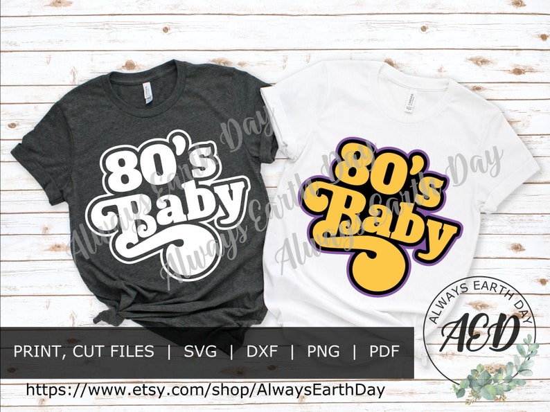 May include: Two t-shirt designs featuring the text "80's Baby" in a retro font. The design on the left is white on a dark grey shirt. The design on the right is yellow with purple outlines on a white shirt.