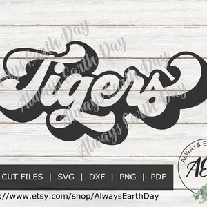 May include: Black and white retro-style graphic design of the word "Tigers" with the text "Always Earth Day" surrounding the word. The graphic is on a white wood background.