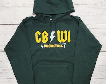 Könnte beinhalten: Ein dunkelgrüner Kapuzenpullover mit einer Vordertasche und einem Kordelzug. Auf der Vorderseite steht der Text "CB WI" in gelben Blockbuchstaben mit einem Blitz-Grafik und dem Wort "TUNDRASTRUCK" darunter.