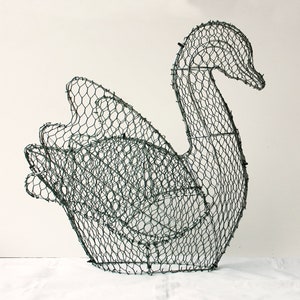 May include: A wire mesh swan sculpture, a decorative piece for a garden or home.