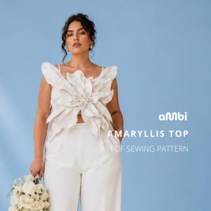 May include: A white Amaryllis top with a large, flower-like design on the bodice. The top is paired with white pants. The text "AMARYLLIS TOP PDF SEWING PATTERN" is visible on a light blue background.