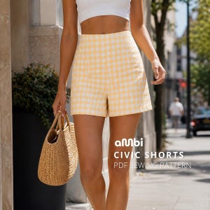 Puede incluir: Pantalones cortos de cuadros amarillos y blancos de cintura alta. Se muestra el patrón de costura PDF "Civic Shorts" de ambi. Se sostiene un bolso de mano de paja en la mano izquierda.