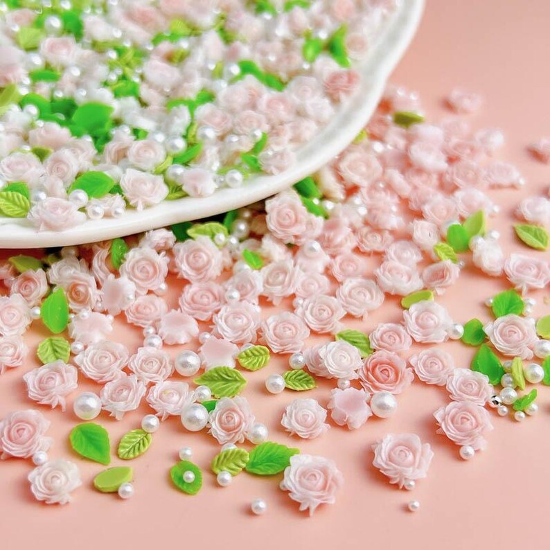 May include: Pink and green flower and pearl sprinkles for crafts and decorations.