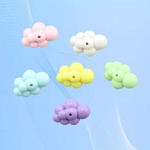 Puede incluir: Seis cuentas de silicona en forma de nube de color pastel con un agujero en el centro. Las cuentas son de color rosa, blanco, amarillo, verde claro, azul claro y morado.