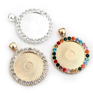 May include: Three round pendant charms with a metal frame and a clear center. The charms are decorated with clear and colorful rhinestones.