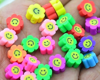 May include: Assortment of colorful flower-shaped beads with smiley faces. The beads are made of plastic and have a hole in the center for stringing.