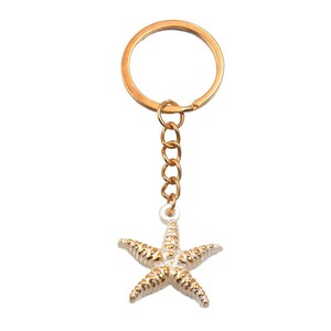 May include: Gold-colored keychain with a starfish charm. The starfish is white with gold accents, and the keychain has a gold ring and chain. The design is simple and elegant, suitable for beach lovers or those who enjoy nautical themes.