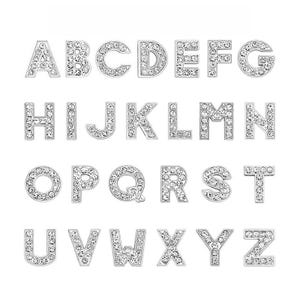 Może przedstawiać: Zestaw srebrnych zawieszek w kształcie liter alfabetu, każda litera jest ozdobiona przezroczystymi cyrkoniami.
