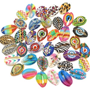 May include: A collection of colorful, hand-painted cowrie shells. Each shell features a unique design, including geometric patterns, flowers, animals, and words like "love".