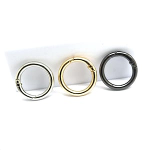 May include: Three metal key rings in silver, gold, and black.