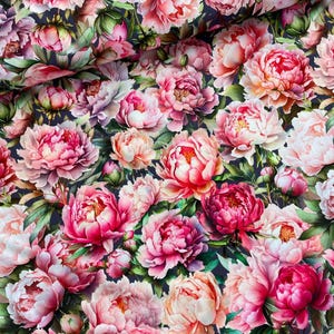 May include: A fabric featuring a dense floral pattern of blooming peonies in shades of deep magenta, soft pink, and white, interspersed with green leaves against a dark navy blue background, creating a continuous botanical print.