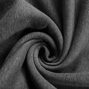 Może przedstawiać: Zbliżenie ciemnoszarej tkaniny o miękkiej fakturze. Tkanina jest mocno zwinięta, tworząc spiralny wzór. Materiał wydaje się być dzianiną lub dżersejem, odpowiednim do odzieży lub tekstyliów domowych.