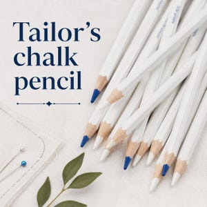 May include: A collection of white tailor's chalk pencils with blue tips arranged in a cluster. The text Tailor's chalk pencil is printed in dark blue on the left side. Two sewing pins with small round heads are visible in the lower left corner.