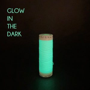 May include: A spool of bright green glow-in-the-dark thread with the label "POLY GLOW Art... col. 1260"