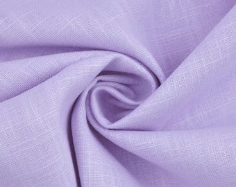 May include: Close-up of a soft, lavender-colored fabric with a subtle woven texture. The fabric is gathered and folded, creating gentle curves and shadows. The material appears to be lightweight and breathable, suitable for clothing or home decor.