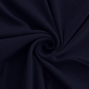 May include: Close-up of navy blue fabric with a subtle, textured pattern. The material is draped, creating soft folds and shadows. The fabric has small, evenly spaced perforations, adding visual interest and a breathable quality. The overall appearance is smooth and elegant.