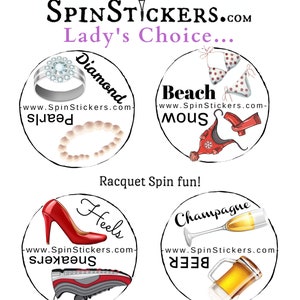May include: Four round stickers with white backgrounds and black borders. Each sticker features a different image and text. The first sticker shows a diamond ring and a string of pearls with the text "Diamond" and "www.SpinStickers.com-pearls". The second sticker shows a bikini and a red scarf with the text "Beach" and "www.SpinStickers.com-mous". The third sticker shows a red high heel shoe and a black and grey trainer with the text "Heels" and "www.SpinStickers.com-sneakers". The fourth sticker shows a glass of champagne and a beer mug with the text "Champagne" and "www.SpinStickers.com-BEER".