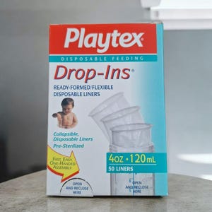 May include: A box of Playtex Drop-Ins disposable feeding liners. The box is blue and red with a picture of a baby and a clear plastic liner. The box says "Ready-Formed/Flexible Disposable Liners" and "4oz. 120mL 50 Liners".