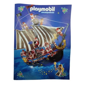 Puede incluir: Un juego de juguetes de barco pirata Playmobil sobre un fondo azul con un tema de noche estrellada. El barco tiene velas marrones, un casco negro y está lleno de figuras de piratas. El logotipo de Playmobil está en la parte superior.