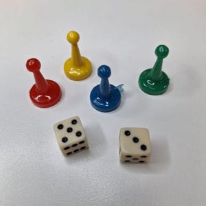 May include: A collection of game pieces, including five colored pawns in red, yellow, blue, and green, along with two white dice with black dots. The pawns have a classic design, and the dice are standard six-sided cubes.