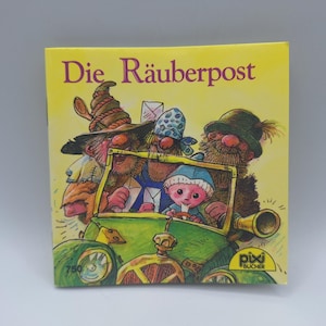 Peut inclure: Un livre pour enfants intitulé "Die Räuberpost" avec une couverture jaune. L'illustration de la couverture représente des personnages de dessins animés dans une voiture verte. Les personnages ont des barbes et des chapeaux. Le livre a le logo "pixi BÜCHER".