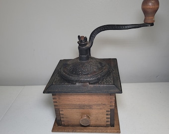 Molinillo de café antiguo, caja de madera, manivela de hierro fundido, relieve floral.