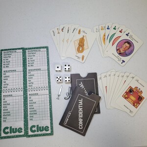 Może przedstawiać: Zestaw gier planszowych Cluedo z kartami, kostkami i pionkami. Gra zawiera karty z podejrzanymi, bronią i pokojami. Elementy gry obejmują nóż, rewolwer i ołowianą rurę. Gra jest na białej powierzchni.