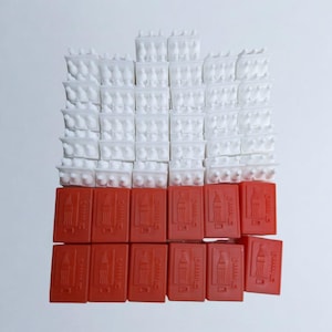May include: A stack of white miniature Coca-Cola bottles with red Coca-Cola mini-fridges underneath.